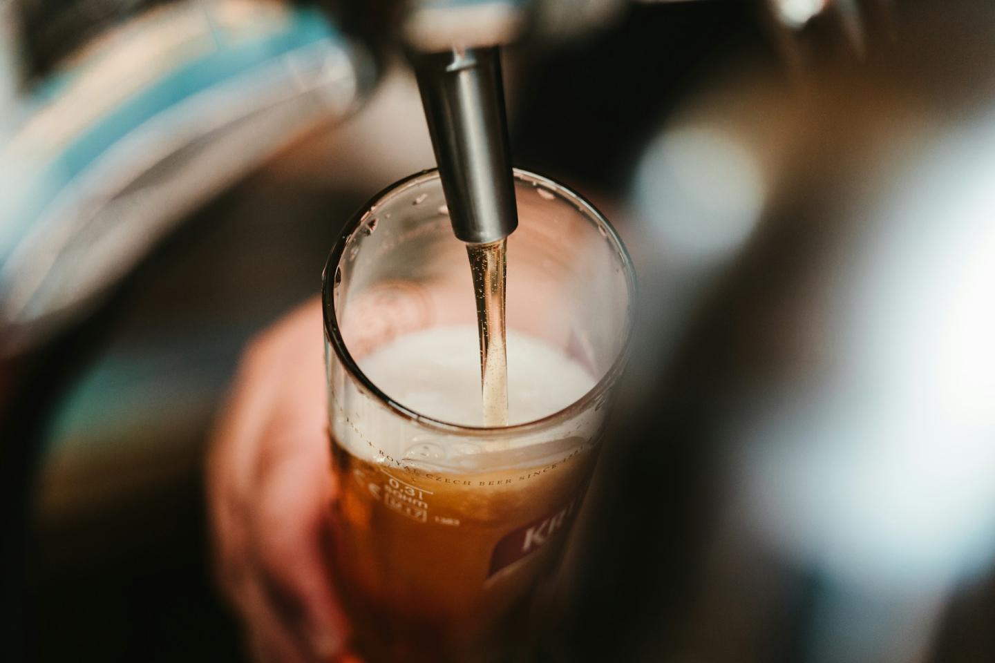 Pouring beer into a glass from a tap.