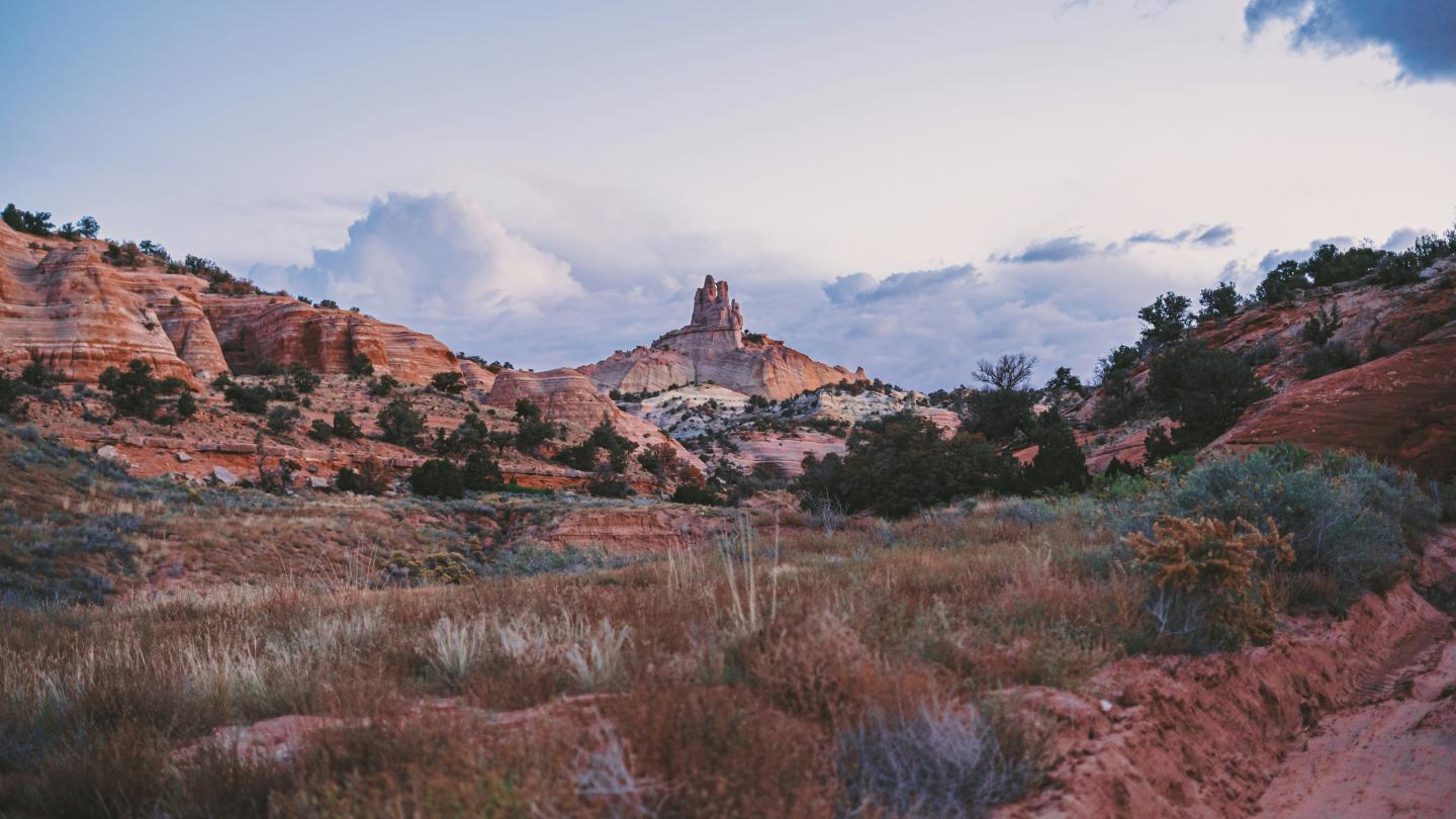 Desert landscape with red rock formations at sunset.