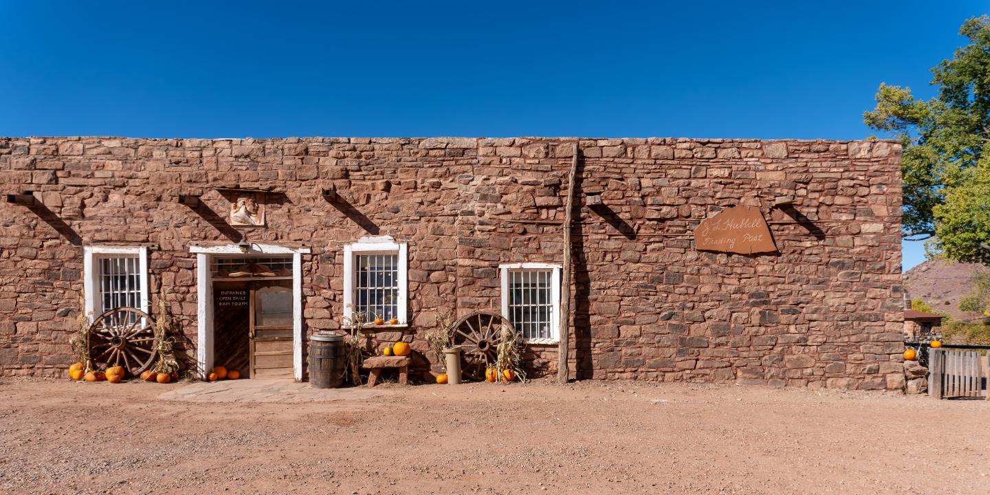 Brick Hubbell Trading Post building with white window frames, rustic decor, and clear blue sky.