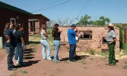 Tourists take a tour with a park ranger outdoors.