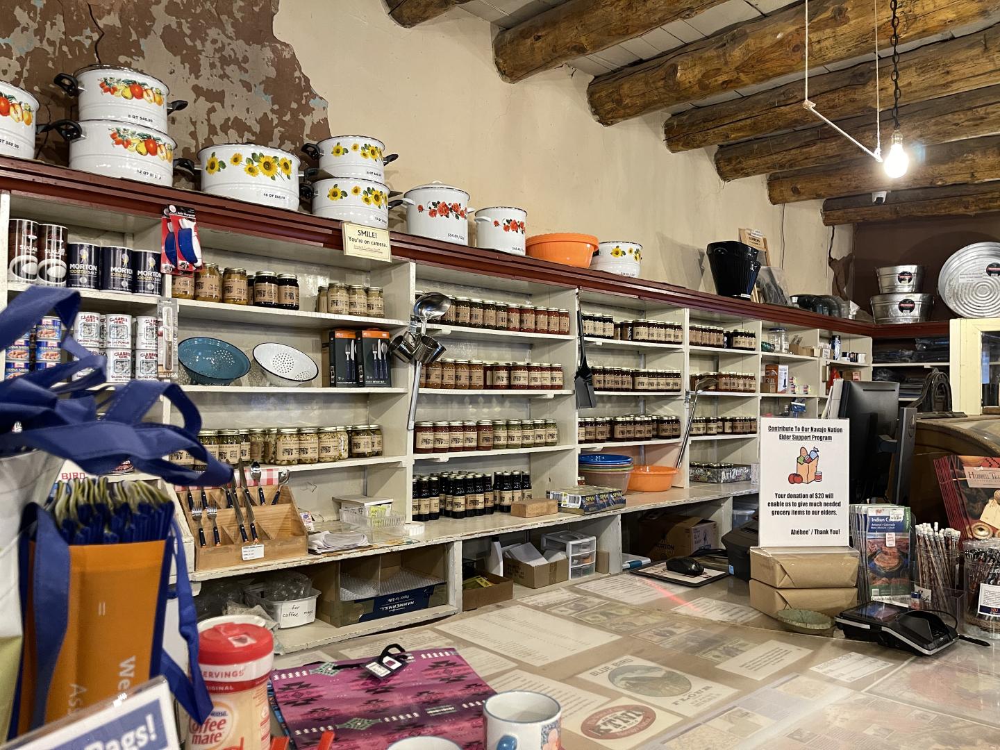 Wooden shelves filled with home goods, and groceries in a rustic store setting.