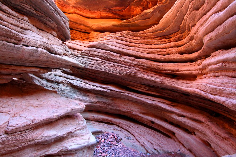 Layered red rock canyon with sunlight illuminating the curves.