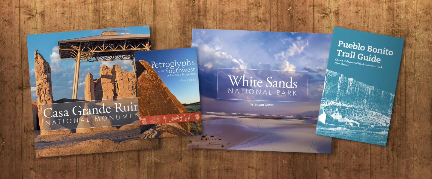 Travel brochures with scenic landscapes on a wooden table.