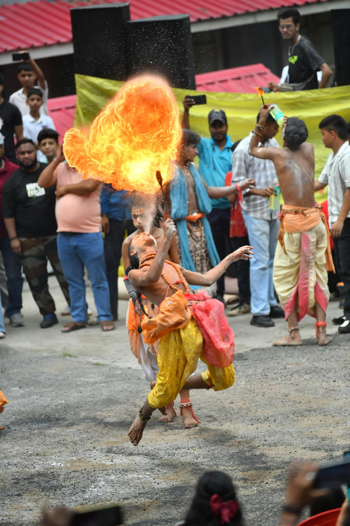 Man breathing fire during outdoor cultural performance.