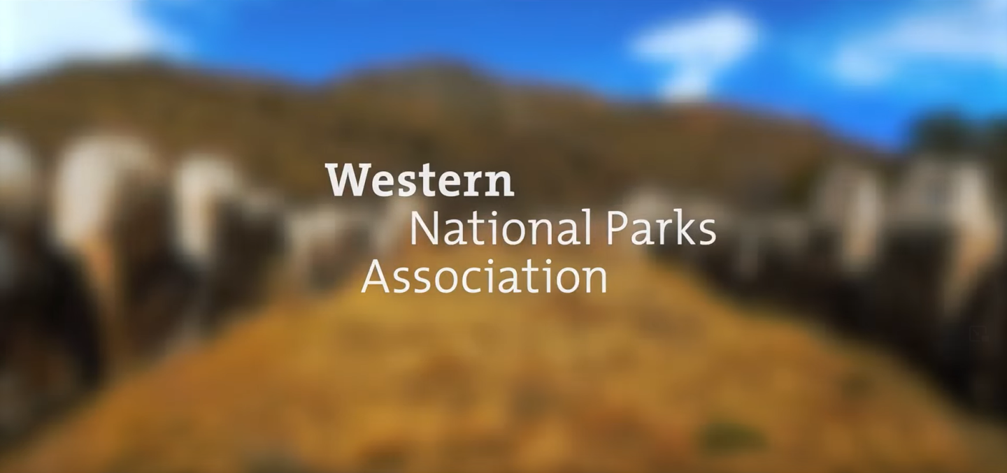 Blurry landscape with hills and blue sky; text reads "Western National Parks Association."