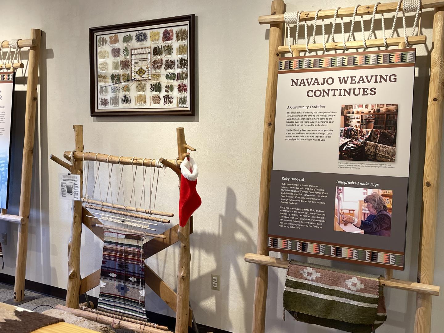 Hubbell Trading Post Visitor Center Navajo weaving exhibit with looms and informational panels on display.