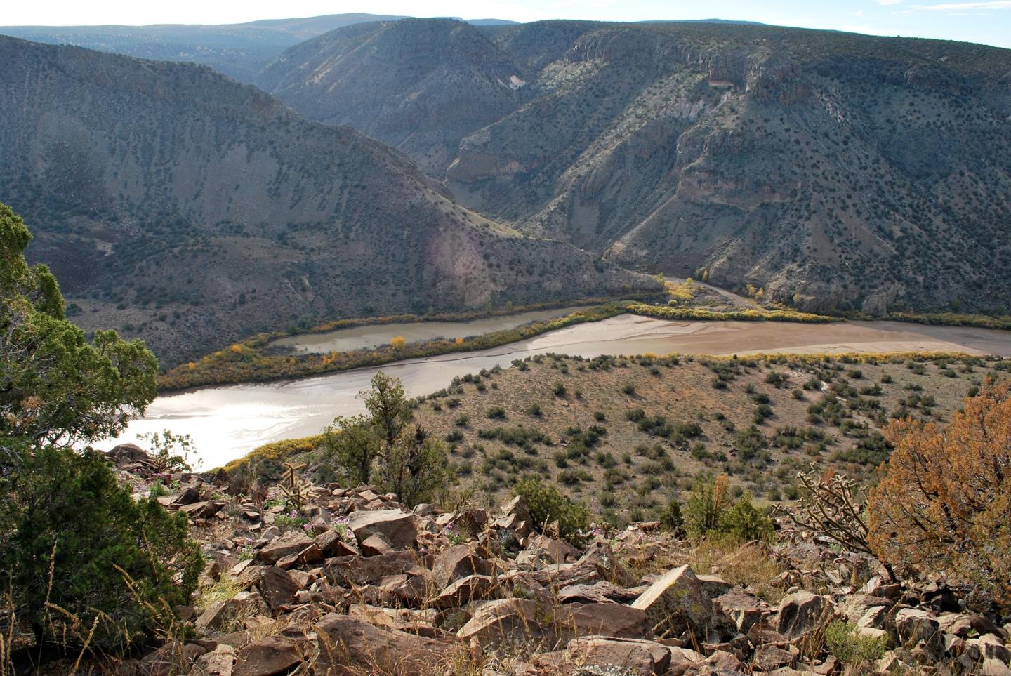 Rocky valley with a river and distant mountains.