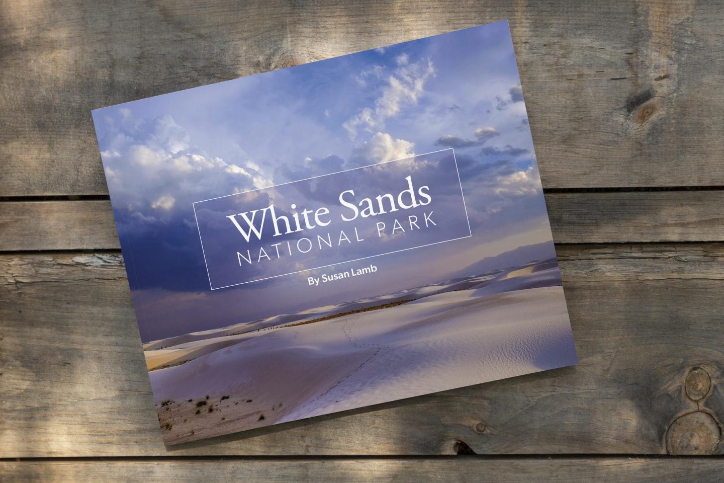 Booklet cover with desert landscape on a wooden table.