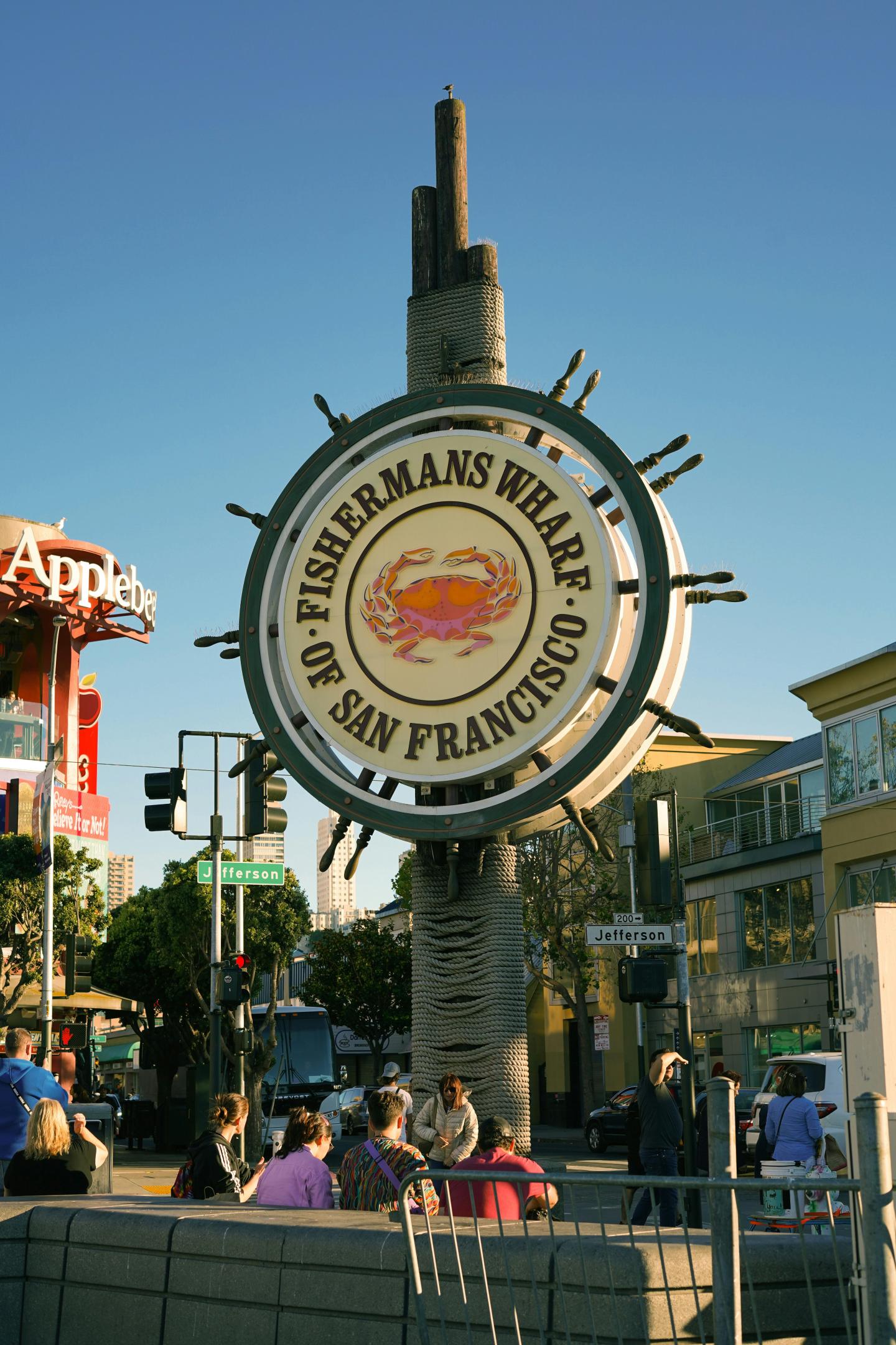 Fisherman's Wharf sign in San Francisco, sunny day, street scene with people.