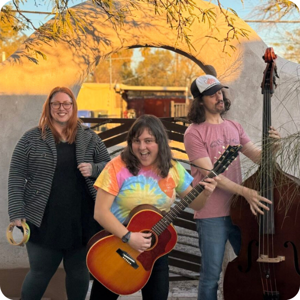 Three musicians playing tamborine, guitar, and upright base outside