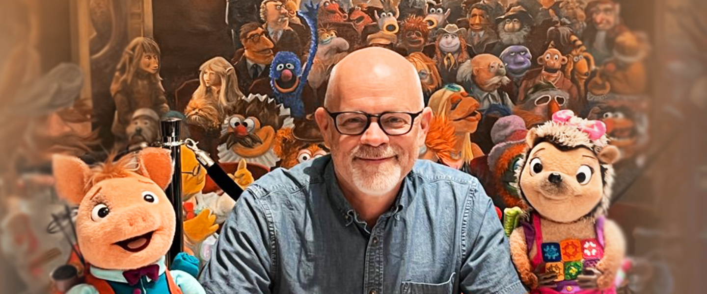 Tom Medema smiling with pig and hedgehog puppets, surrounded by colorful characters.