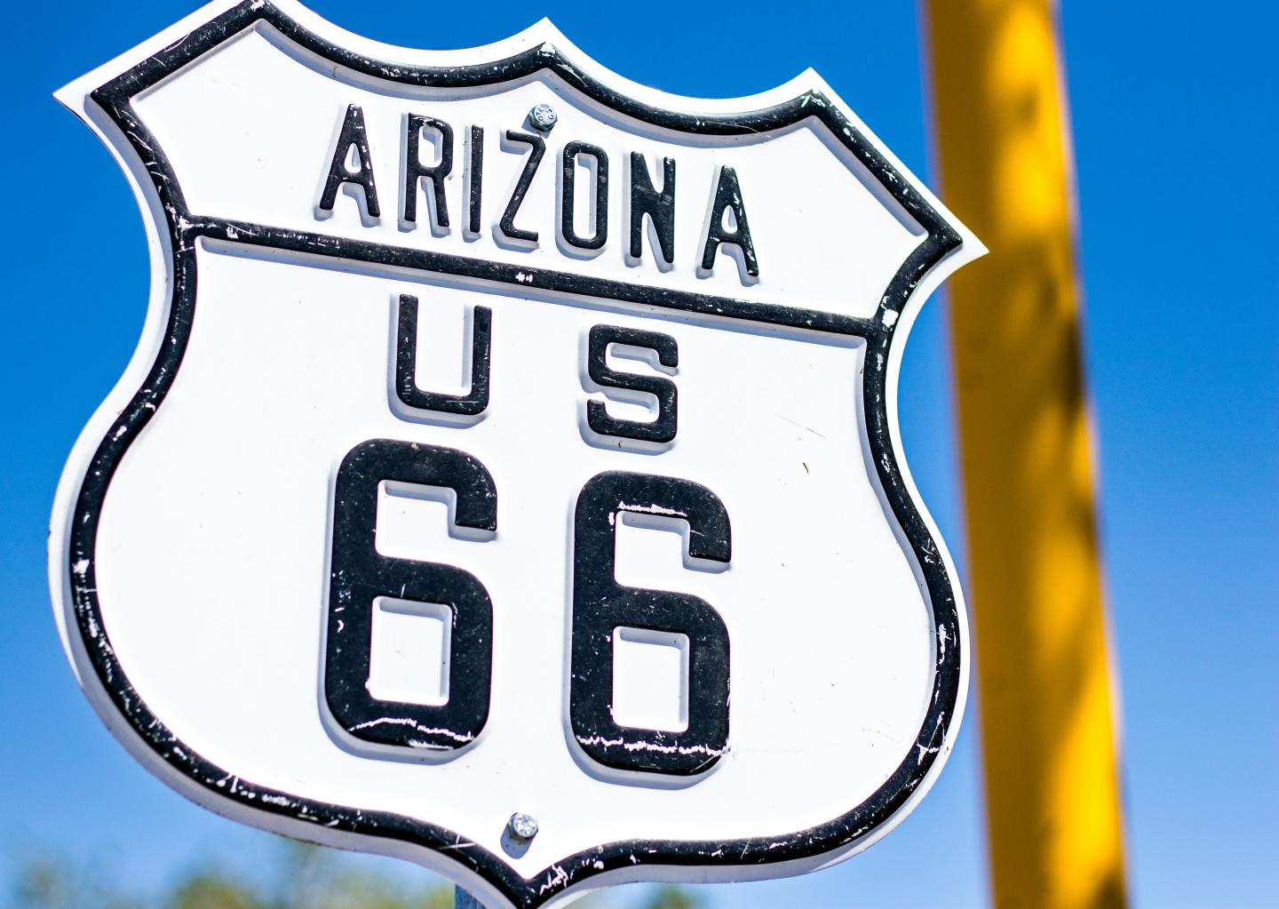Arizona Route 66 sign against a blue sky.