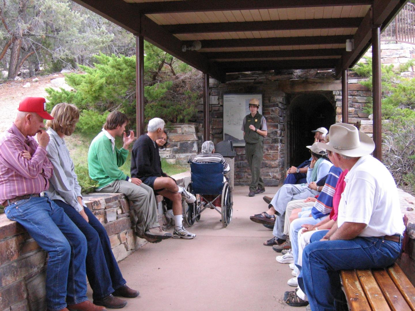 Park ranger talks to a seated group, including a person in a wheelchair.