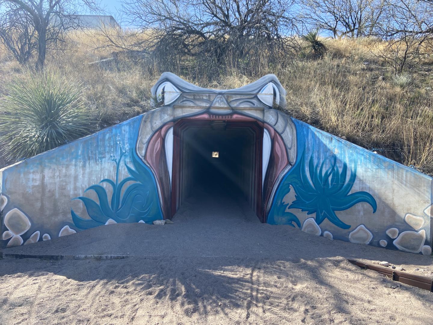 Tunnel entrance painted as a snake’s open mouth with vivid colors.