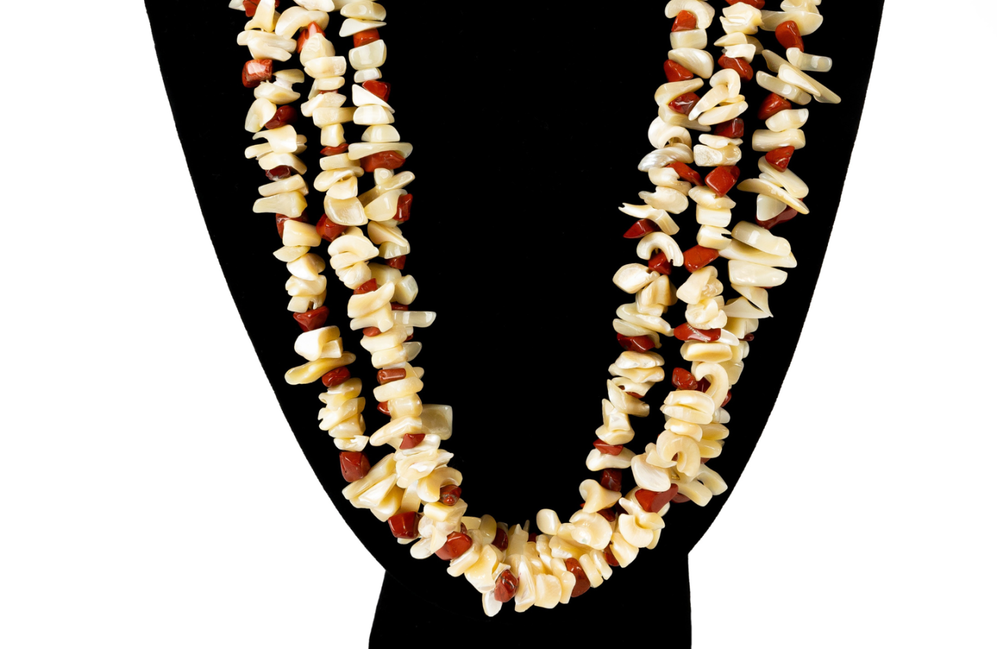 Shell and bead necklace on a black display stand.