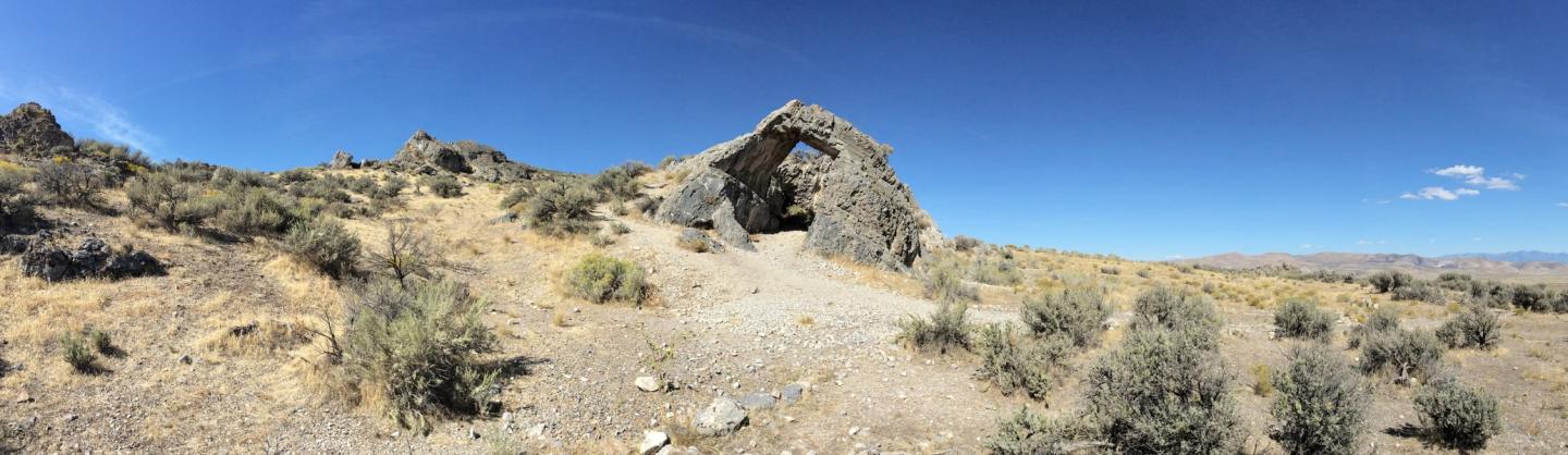 Rocky desert landscape under clear blue sky.