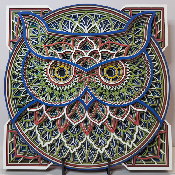 Intricate owl design in colorful layered patterns.