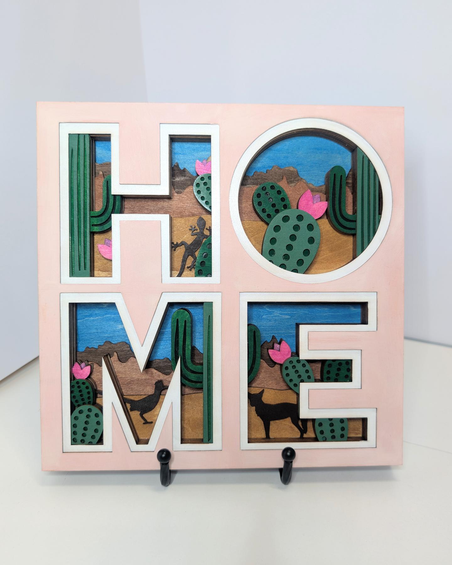 HOME sign with desert cactus art inside letters.