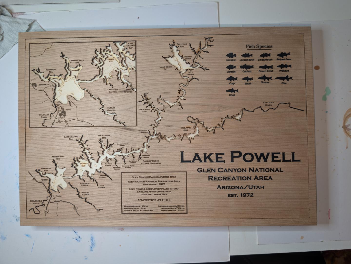 Wooden map of Lake Powell with topographical details and fish species engravings.