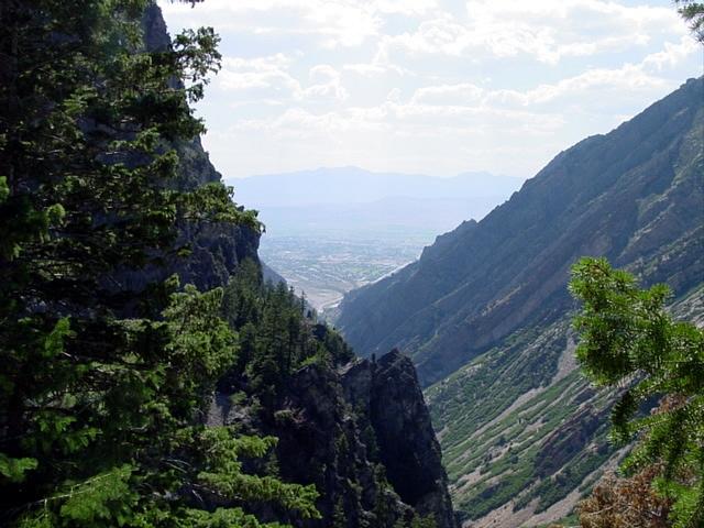 Mountain valley with trees and distant hazy view.