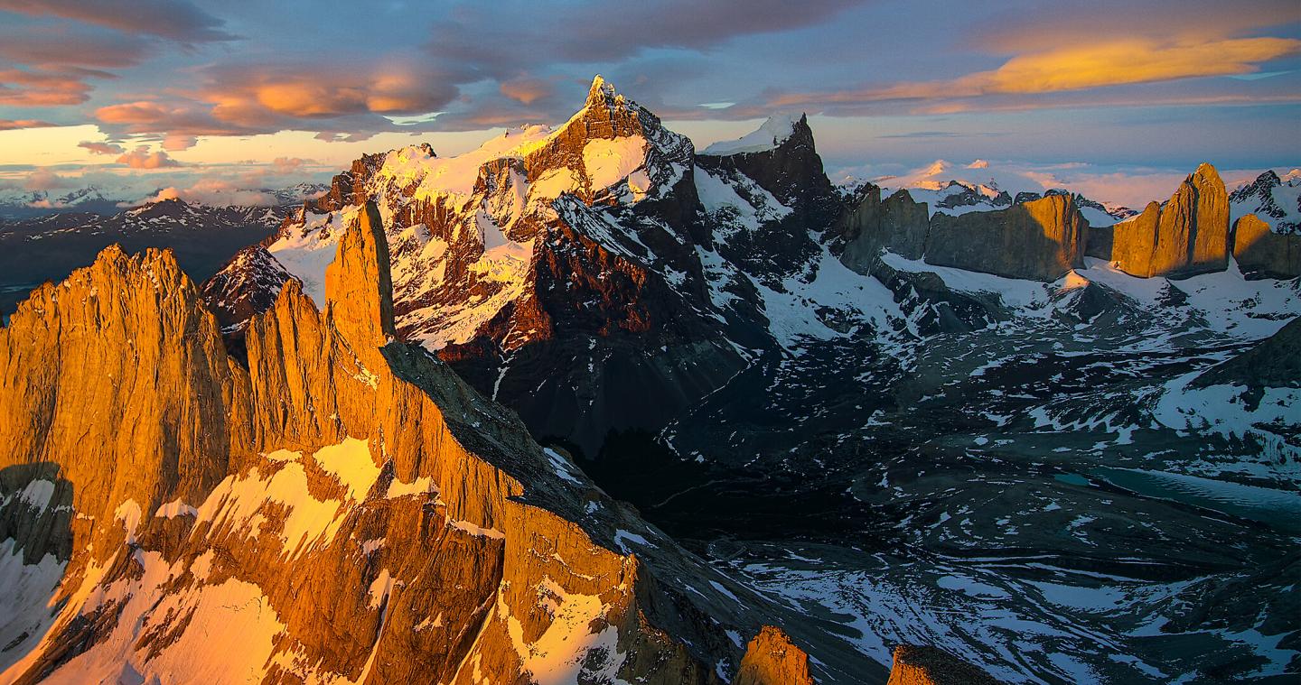 High peaks of the Andres Mountain range covered in snow and golden light.