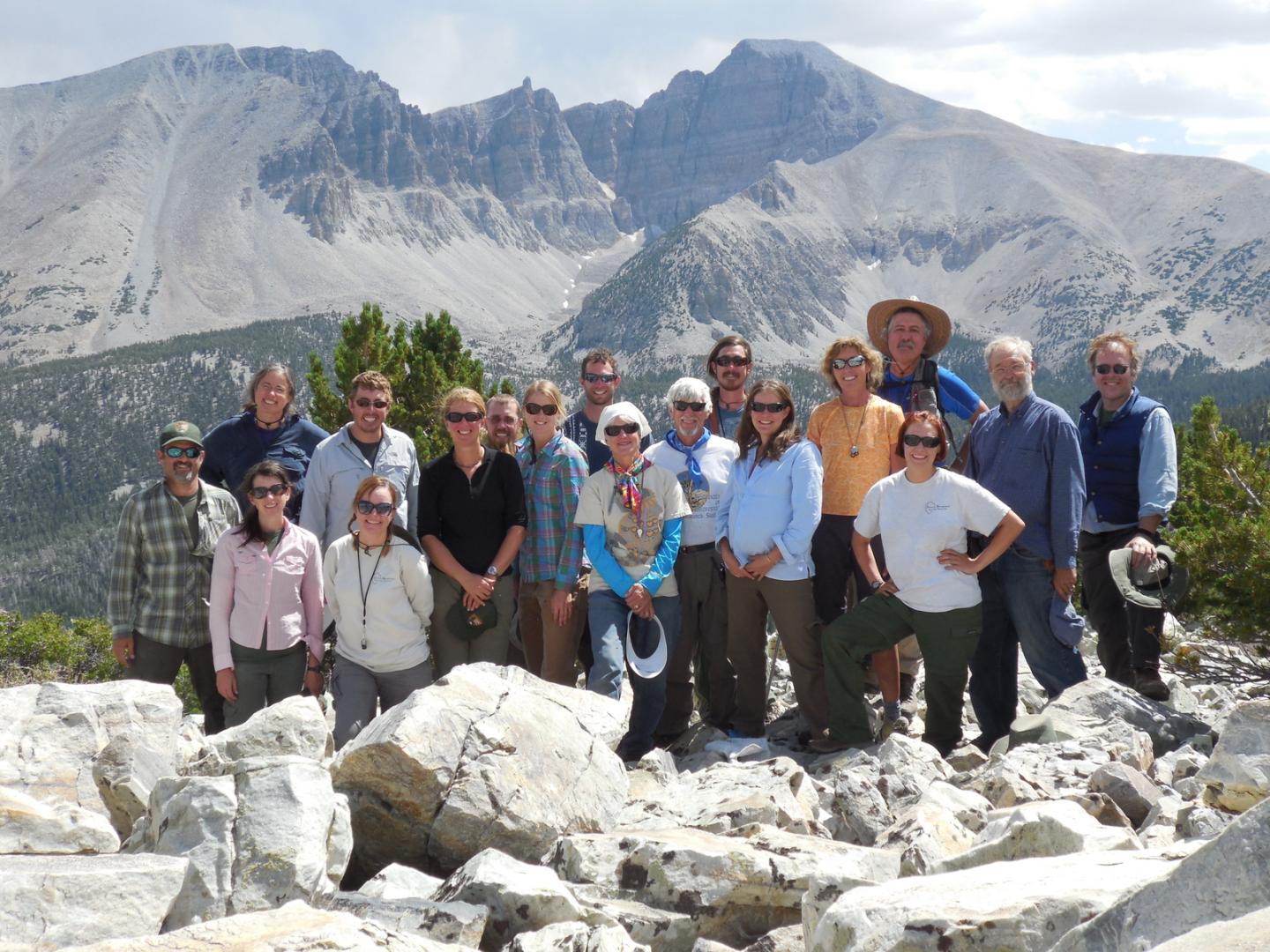 Group of people outdoors with mountains in the background.