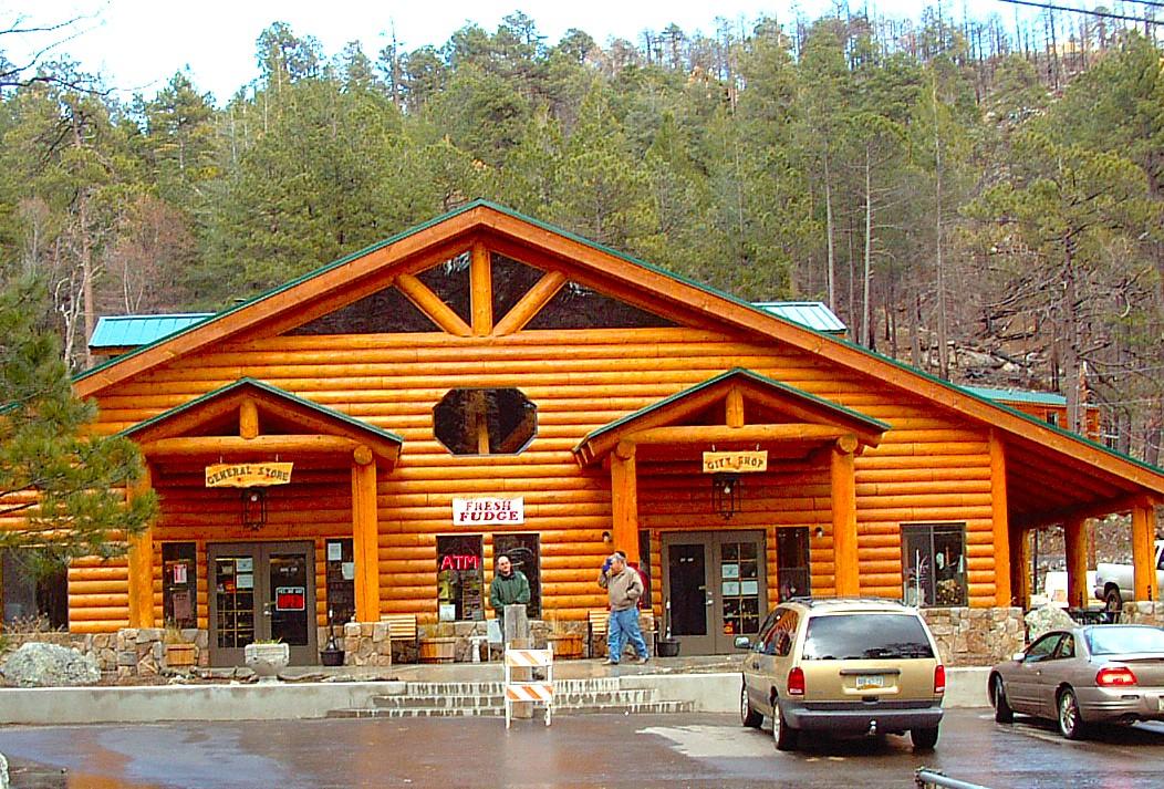 Log cabin-style building with cars parked in front, surrounded by trees.