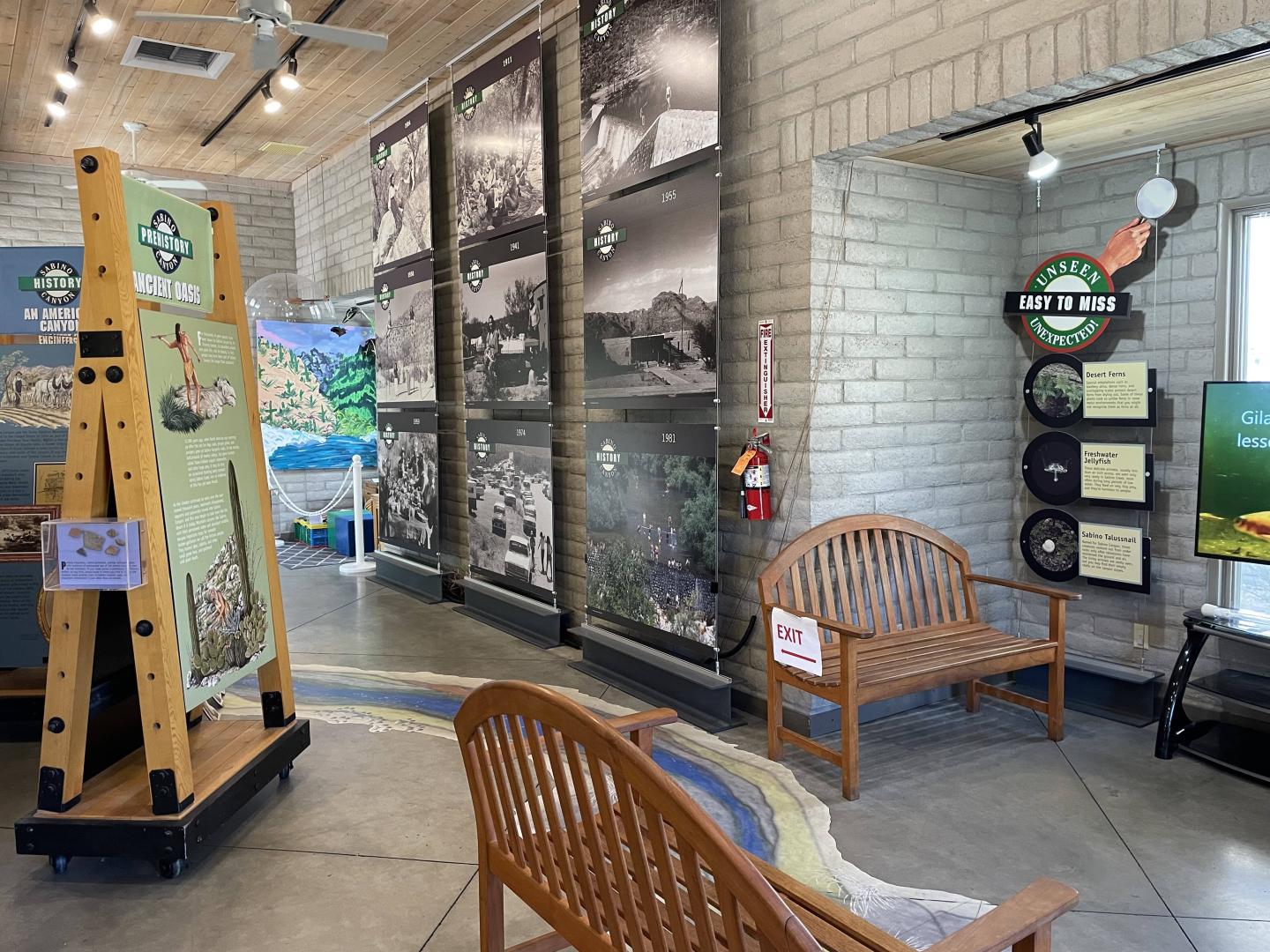 Visitor center at Sabino Canyon with benches, photo displays, and wooden structures.