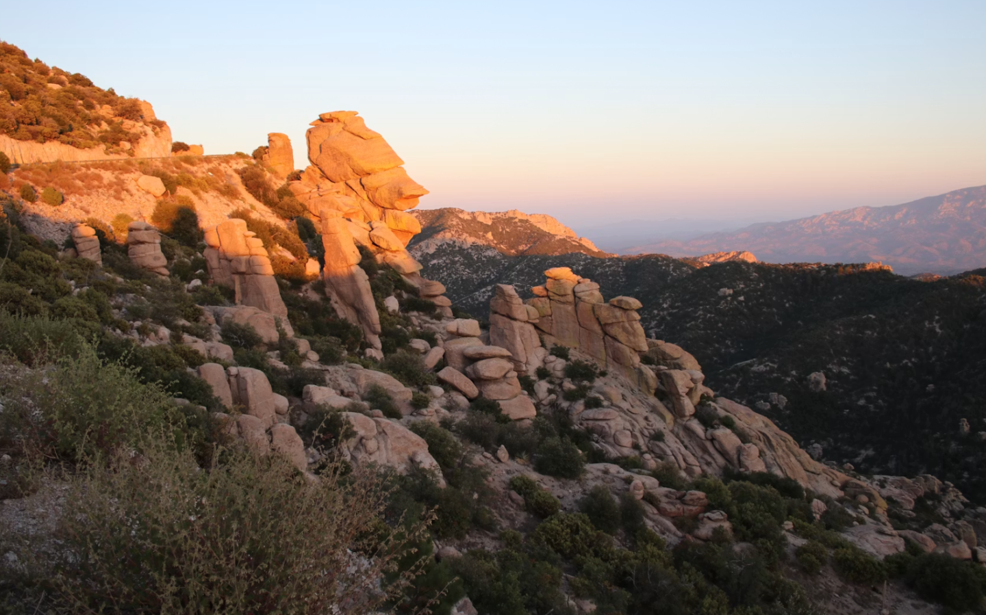 Rocky mountainside at sunset with warm orange light.