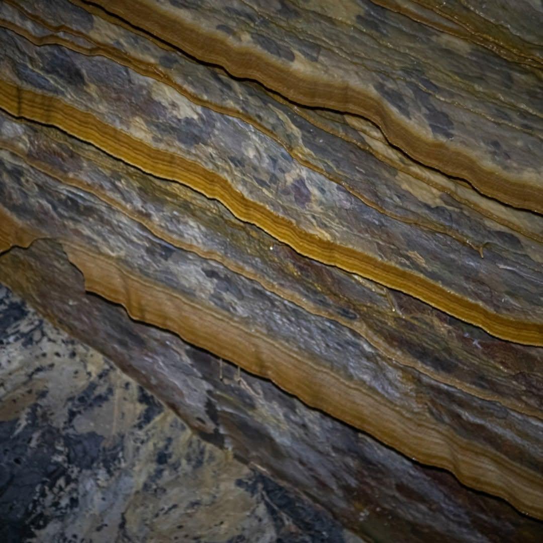 Rock layers with wavy patterns and earthy tones.