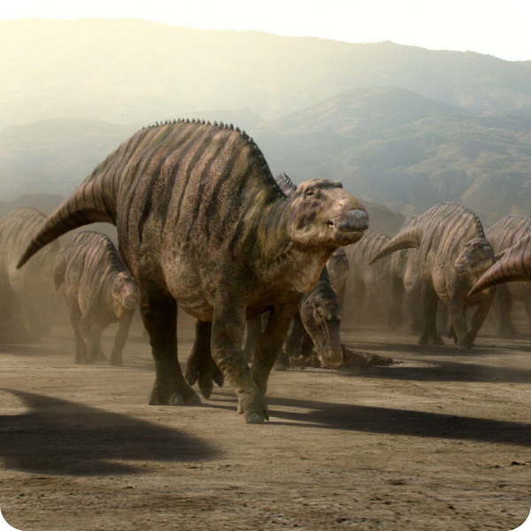Dinosaurs walking in a dusty, mountainous landscape.
