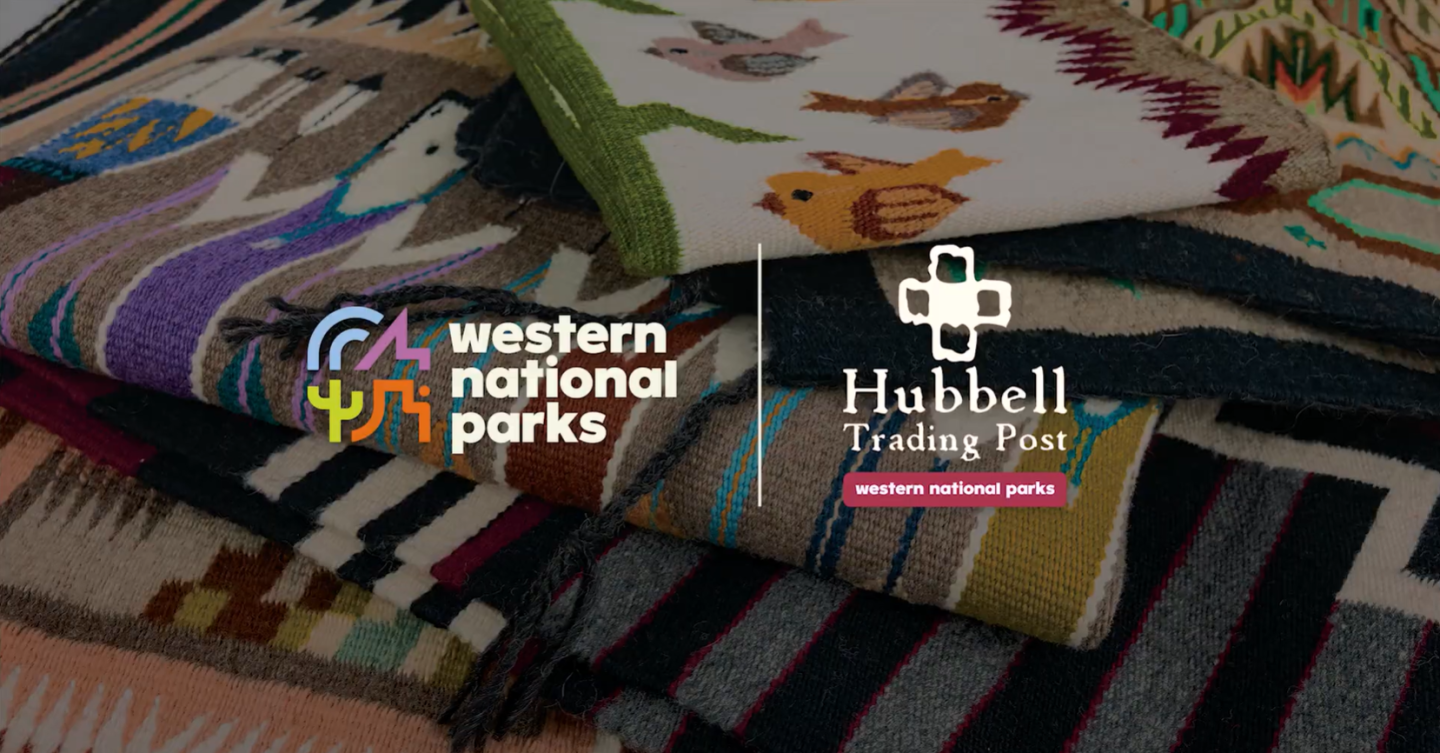 Stack of colorful woven blankets with logos for Western National Parks and Hubbell Trading Post.