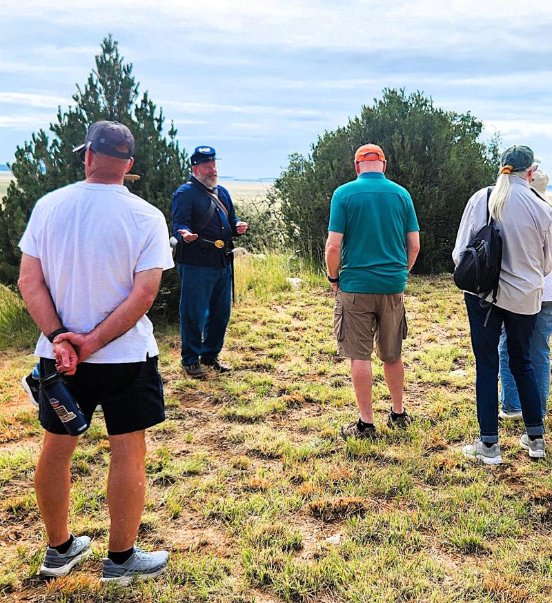 A uniformed living history interpreter speaks to a group.