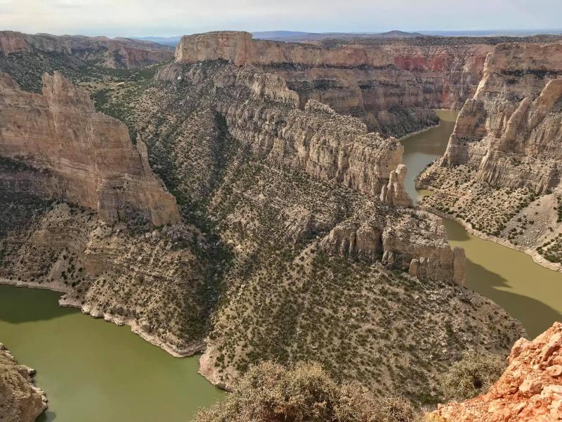 The towering walls of the Devil Canyon as it combines with Bighorn Canyon dotted with greenery.
