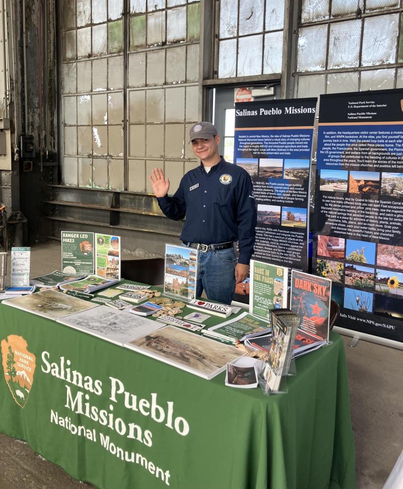 A park ranger at a table providing information.