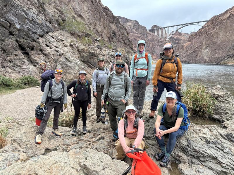 Volunteers and NPS staff stand next to the Colorado River