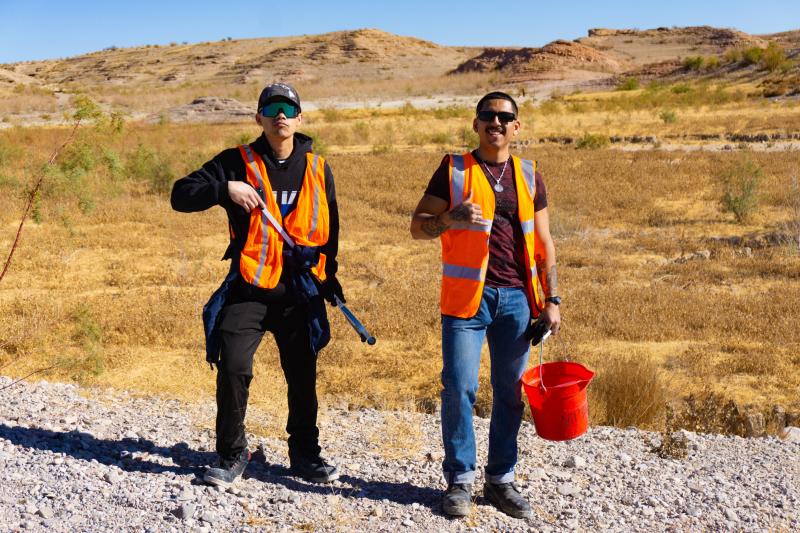 Volunteers standing in the desert with trash cleanup supplies