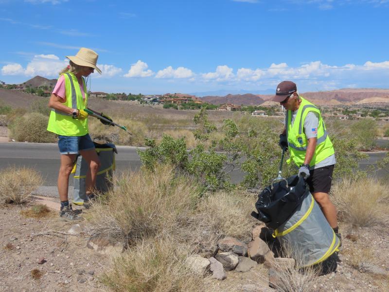Volunteers wearing high-visibility safety vests picking up trash