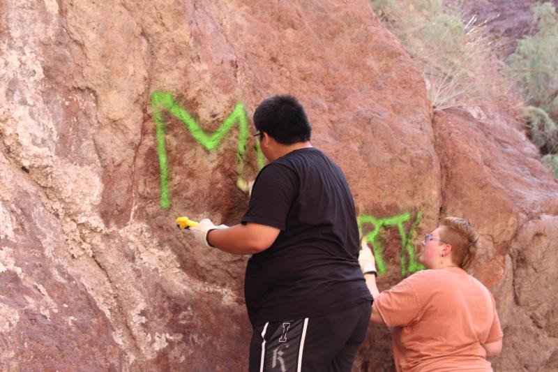 Volunteers scrubbing graffiti from canyon walls