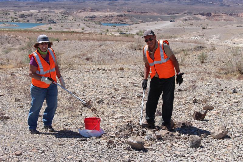 Volunteers smiling with their trash supplies