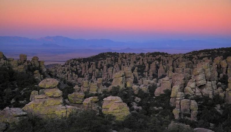 Rock pinnacles at Chiricahua National Monument under a colorful sunset sky.