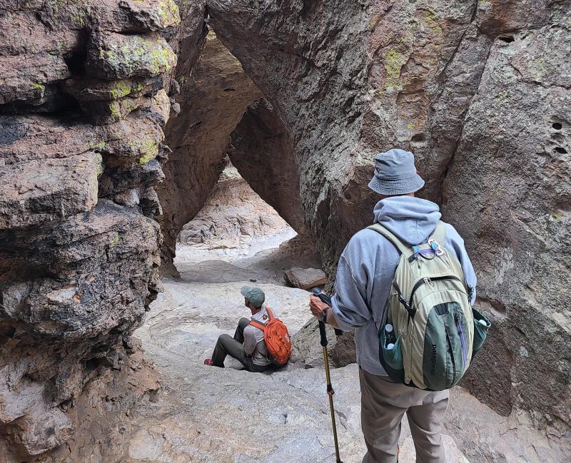 hikers with rock boulders beside and above