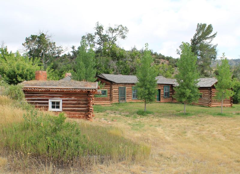 Historic cabins of the Lockhart Ranch surrounded by green foliage.