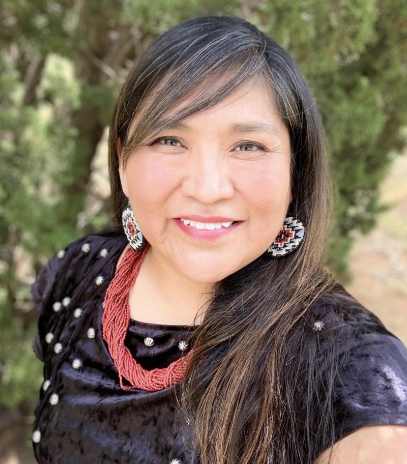 Diné artist Janet Yazzie wears a black shirt and red necklace.