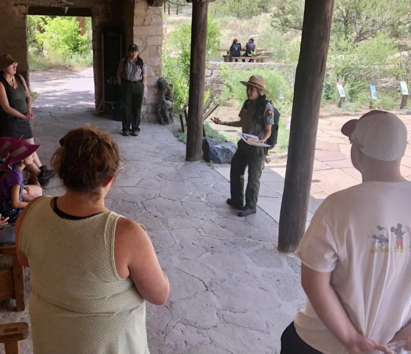 a group of visitors gather around a ranger talking