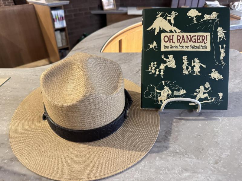 The book "Oh Ranger! True Stories from our National Parks" posed with a ranger hat.