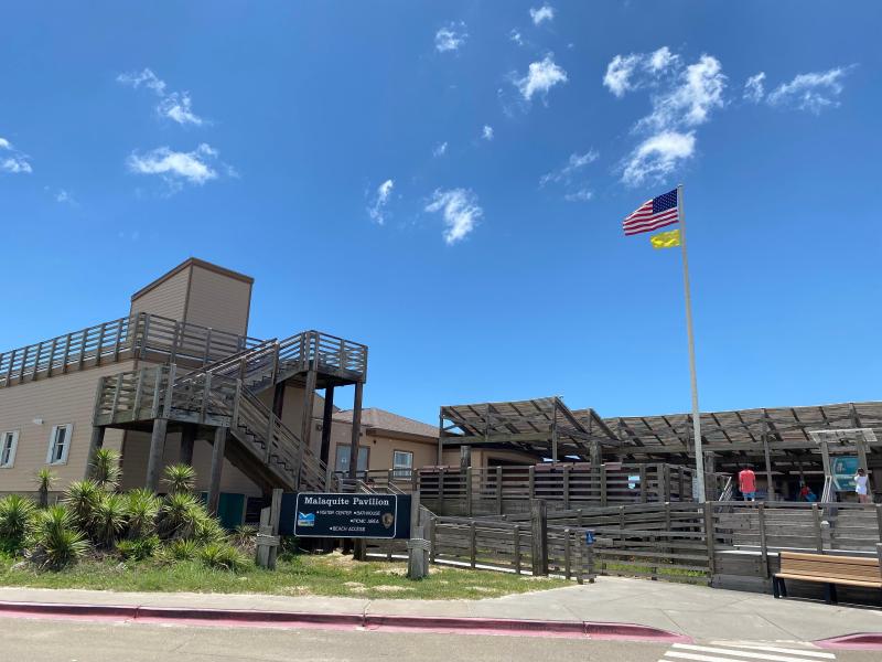 A large building with decks and an American Flag on a flag pole.