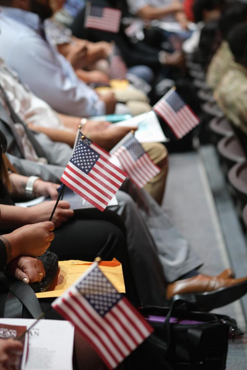 A row of audience members holding miniature U.S. flags.