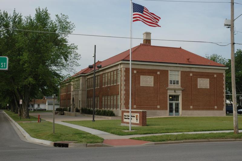 The Monroe School with an American flag in front.