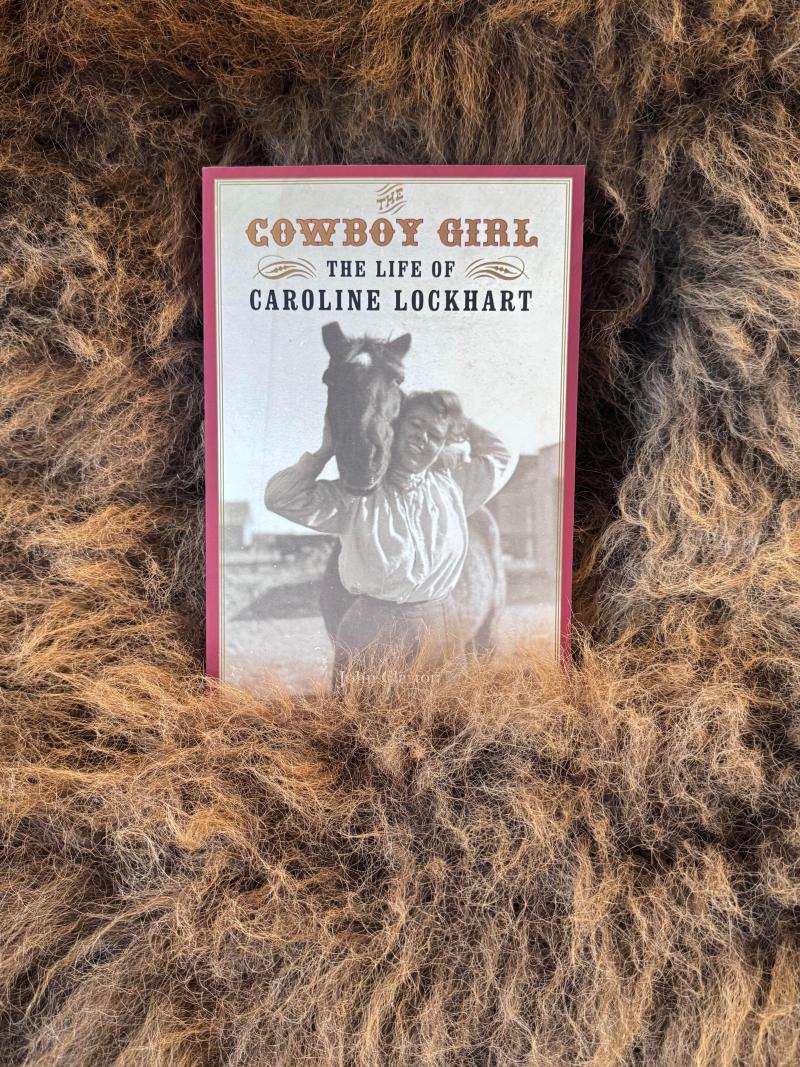 Book titled 'Cowboy Girl: The Life of Caroline Lockhart' resting on a textured brown fur background.